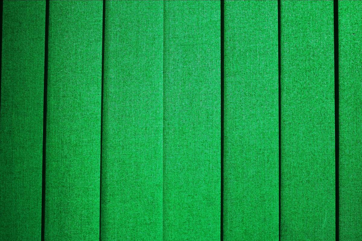 Green mop pads attached to a flat mop head on a hardwood floor, showing clean streak-free results
