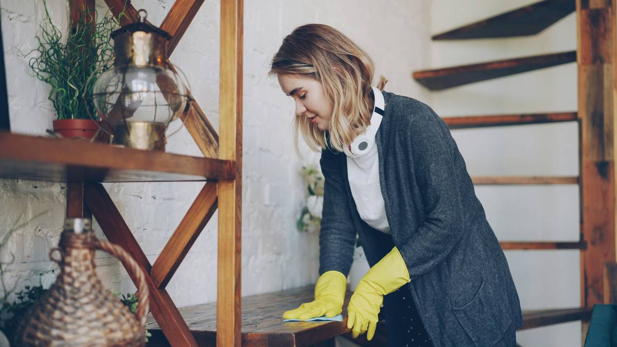 Woman mopping hardwood floor with reusable pad and all natural mop solution in bucket